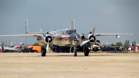 American B-25 Mitchell bomber leaves parking lot in direction runway. Video stock 118804464