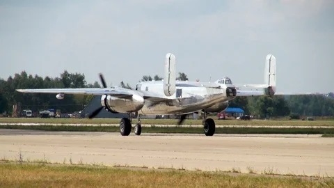American B-25 Mitchell bomber leaves parking lot in direction runway. Stock Footage 118804586