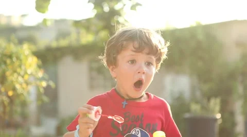 American boy blowing soap bubbles and surprise face Stock Footage 42266626
