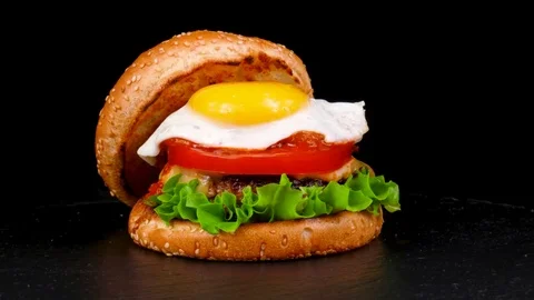 American Burger with Egg and fresh vegetables, on black stone tray Stock Footage 84652960