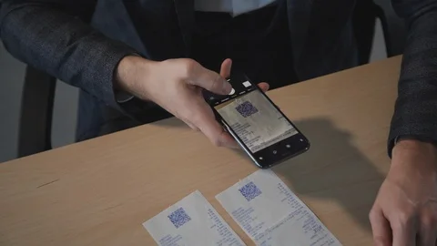 American businessman entering code ising smartphone sitting at table in office Stock Footage 115655668