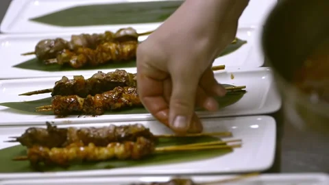 American chef puts fried meat on plate while working by table in kitchen irrl. Stock Footage 134864259