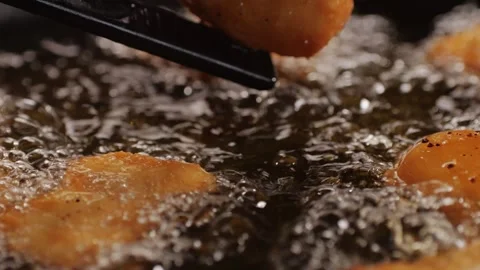 American chiken nuggets broiling on black frying pan close-up macro. Breaded Stock Footage 263087053