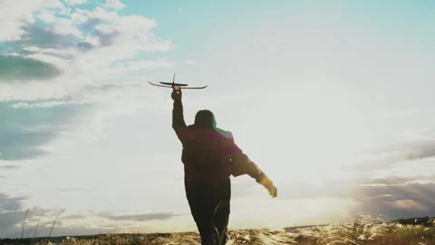 American child boy runs through park with toy plane his hand sunset sky Stock Footage 247377703
