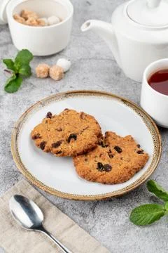 American chocolate chip cookies on rustic plate with sugar, mint and teapot o Stock Photos