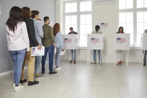 American citizens standing in queue at vote center going to put ballots in bin Stock Photos