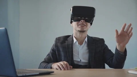 American designer get virtual experience using vr glasses at table with laptop Video stock 115217566
