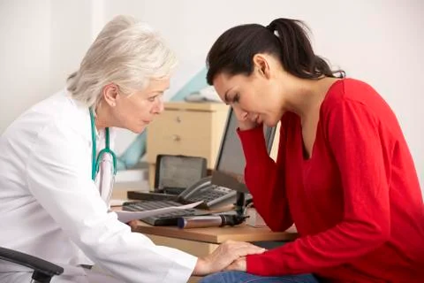 American doctor with depressed woman patient Stock Photos
