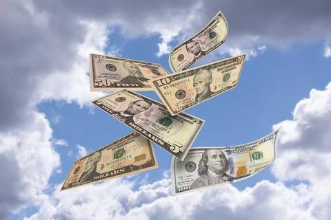 American dollar notes of different value flying with blue sky and clouds Stock Photos