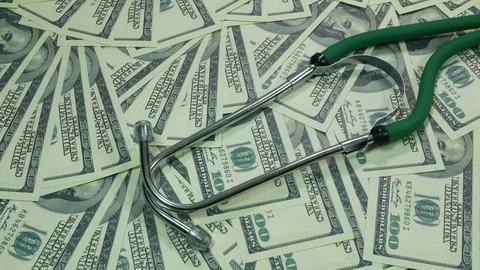 American dollars and a stethoscope on a table Stock Footage 88290289