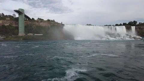 American Falls and the Niagara Falls Observation Tower above a docked tour boat Stock Footage 345996059