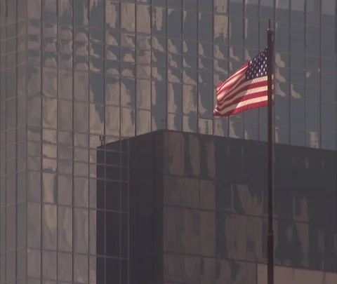 American flag and clouds reflected in glass of Houston skyscraper Stock Footage 86697990
