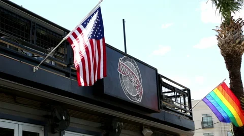 American Flag and Rainbow Flag Fly at Woody's in Dallas Texas Stock Footage 51553077