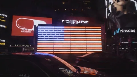 American Flag Behind Flowing Traffc With Yellow Cabs in Times Square. Video stock 102578786