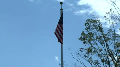 American flag blowing in wind, blue sky 库存影片 304367862