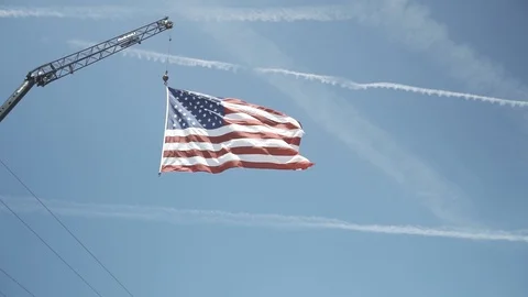 American flag blowing in wind hanging from crane Stock Footage 119282579