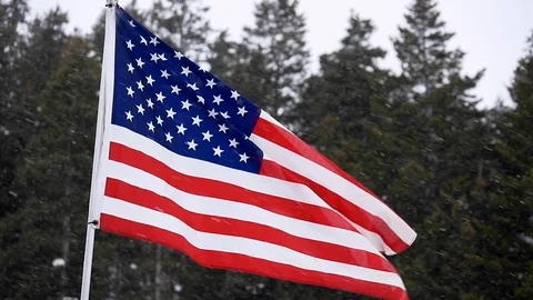 American flag blowing in wind in slow motion during winter snow storm. Stock Footage 108014495