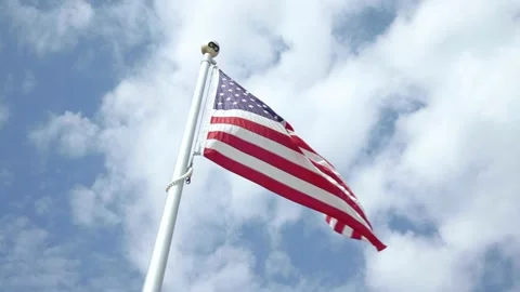 American flag blowing in the wind on a sunny day  Stock Footage