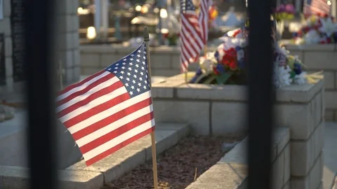 American flag blows gently in the wind in a cemetary Vidéo 94159704