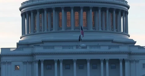 An American flag blows in the wind at the US Capitol building in Washington, DC. Stock Footage 136339035