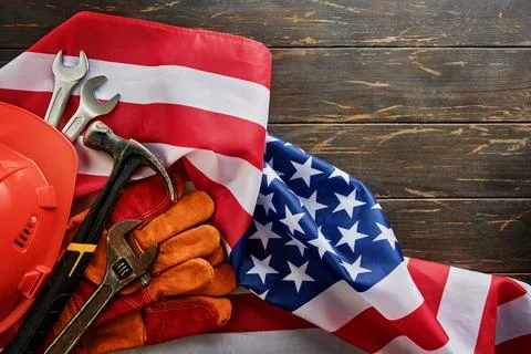 American flag with construction tools, safety helmet, hammer, wrench and work Stock Photos