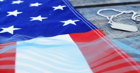 American flag with dog tags on rustic wooden surface, creating patriotic Stock Footage 304763355
