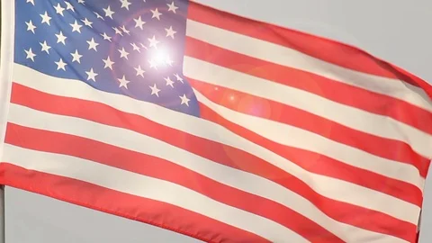 American flag flapping slowly, the Sun behind Stock Footage 86517999