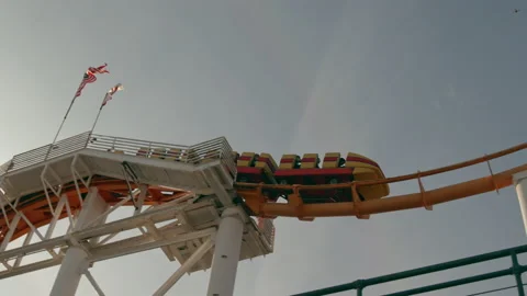 American flag flaps as rollercoaster dips over first big hill and out of sight Stock Footage 134070698