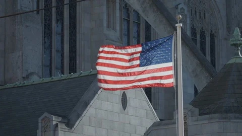 American Flag flies at cathedral Stock Footage 129523977