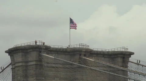 An American flag flies over Brooklyn Bridge - slow motion Stock Footage 44102449