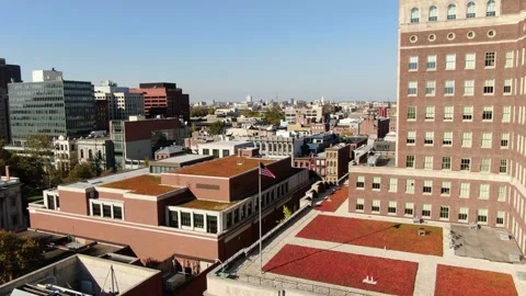 The American flag flutters in the wind among high-rise buildings. Stock Footage 219651216