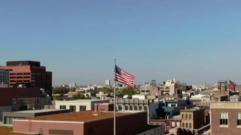 The American flag flutters in the wind among high-rise buildings. Stock Footage 219651247