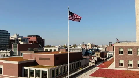 The American flag flutters in the wind among high-rise buildings. Stock Footage 219651258