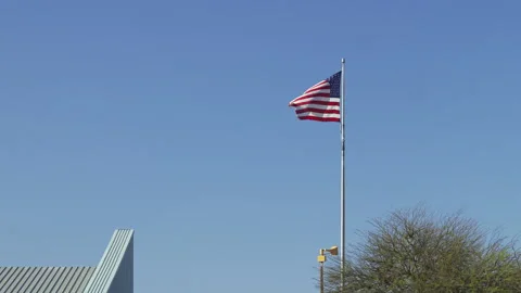 American Flag Flying High Blue Sky Modern Building Stock Footage 309028451