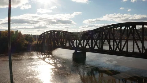 American Flag Flying High Next To Train Bridge Along River Stock Footage 99001989