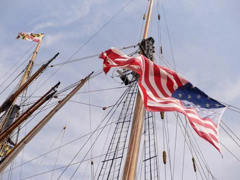American flag flying from a ship mast on a beautiful summer day Stock Photos