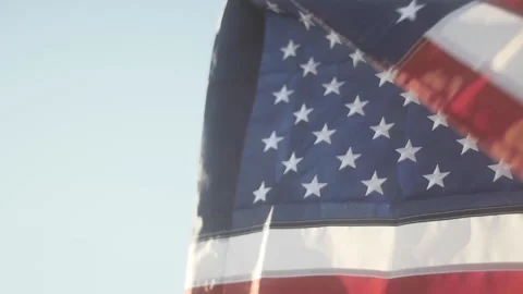 American Flag Flying in Slow Motion, Low Angle Close Up in a Clear Blue Sky Vidéo 138573318