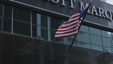 American flag flying in the wind hanging on a skyscraper building in the Stock Footage 110768539