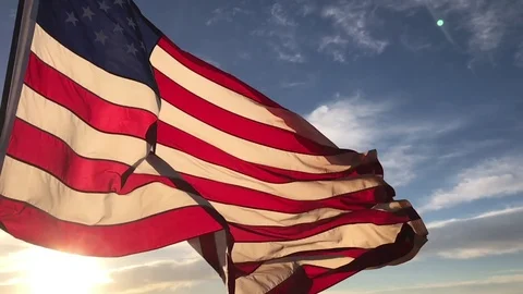 American flag flying in the wind at sunrise slow motion Stock Footage