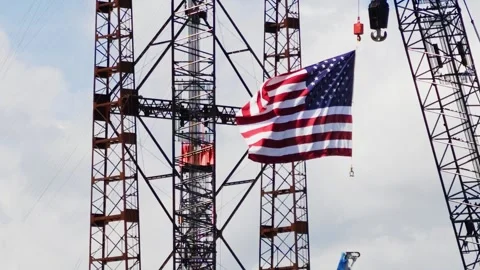 American flag hanging from crane at construction site, slow motion 스톡 동영상 344743463