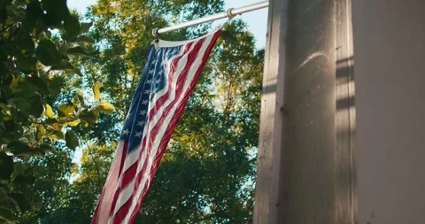 American flag hangs from a house pole in sunlight Stock-Footage 343322870