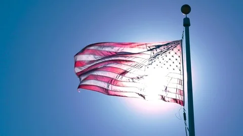 American Flag Illuminated by Sun Waving in Wind, 4K Stock Footage 70792474