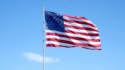 American flag on pole is waving in a clear blue sky. Stock Footage 106908866
