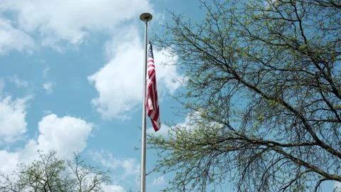 American flag seen flying high on a flagpole Stock Footage 274907802