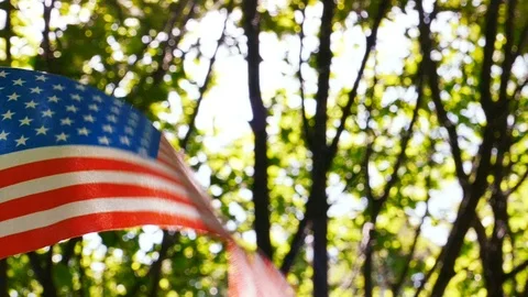   American Flag in slow motion close up sunny scene. Blurred wood background Stockbeeldmateriaal 92722165