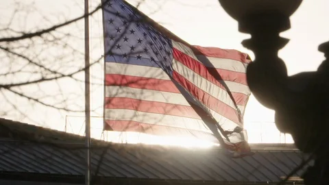 American Flag Slow Motion Sunset Silhouette Blowing in Wind Stock Footage 125553971