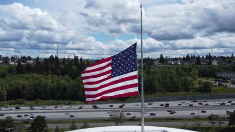 American Flag Soaring Over Highway in Tacoma, WA Stock Footage 194563780