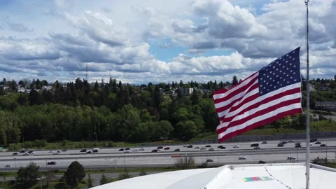 American flag in a strong wind revealed while tracking busy Interstate Stock Footage 194563064
