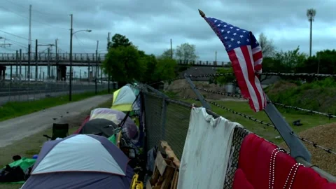 American Flag Stuck on Barbed Wire Over Homeless Camp Stock Footage