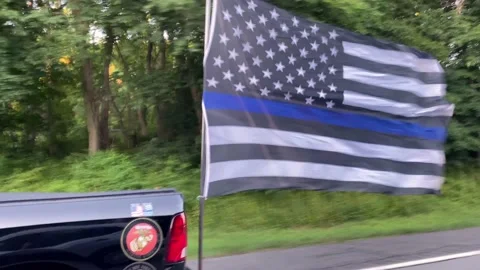 American Flag in Thin Blue Line Motif Flies Behind Truck Stock Footage 170946089